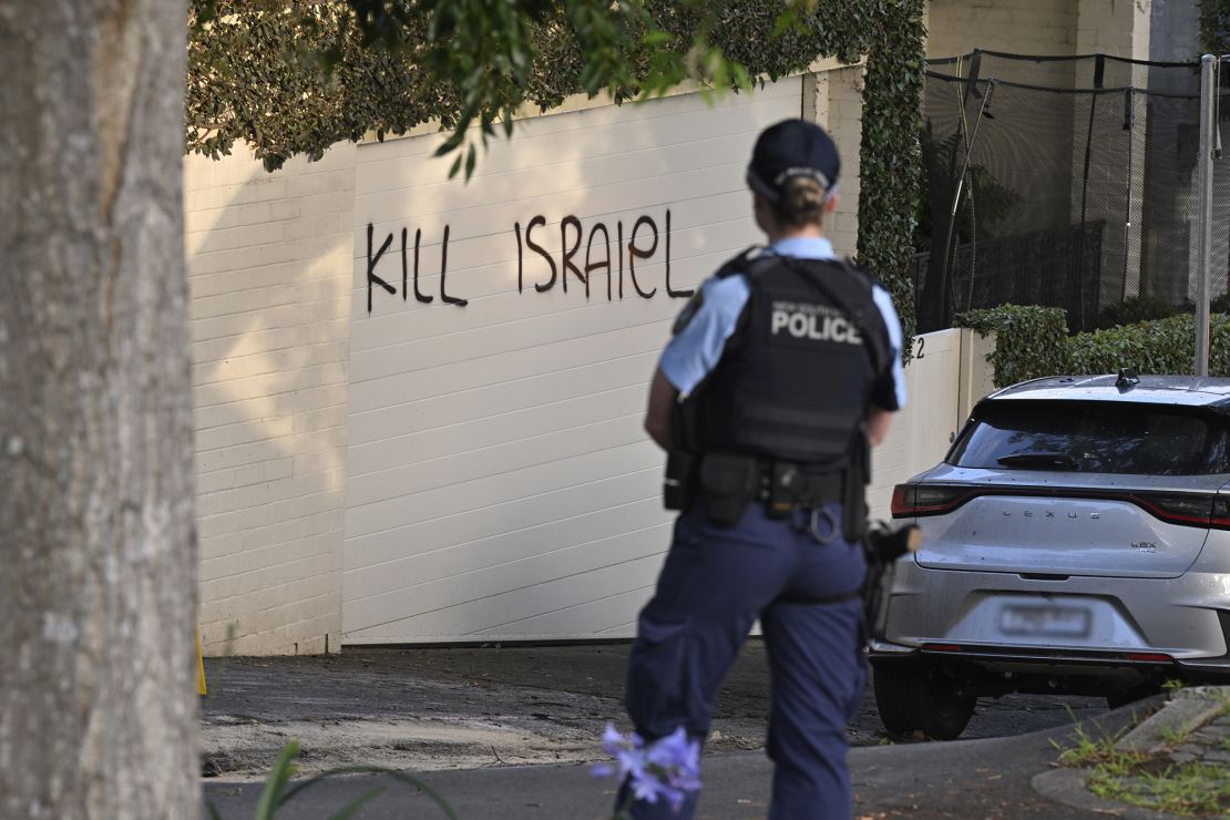 A police officer stands near anti-Israel graffiti sprayed on a wall in Sydney, Dec. 11, 2024.