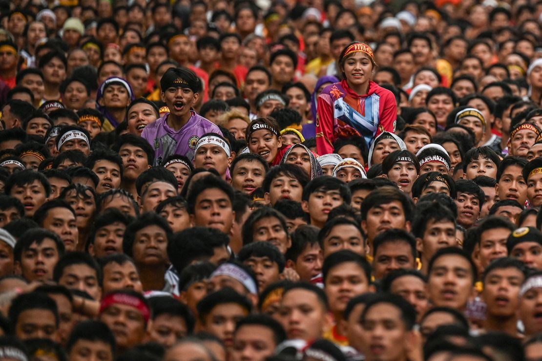 A girl peeks out from the crowd during the procession in Manila on Thursday.