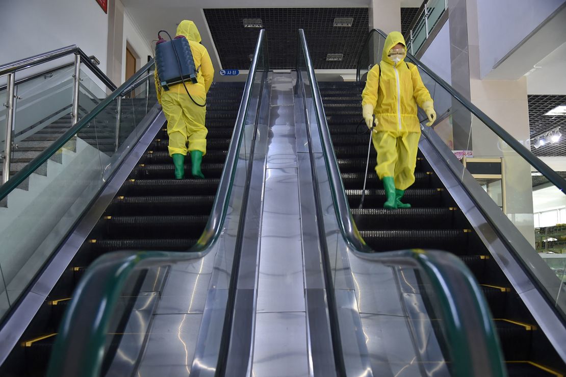 Employees spray disinfectant at a department store in Pyongyang on March 18, 2022.